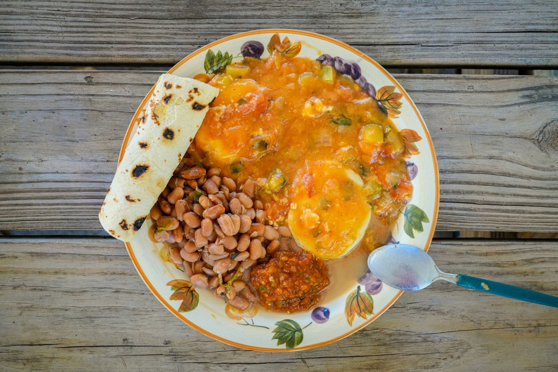 A courtyard table set with coffee, eggs, beans and tortillas for an early start in highland Honduras